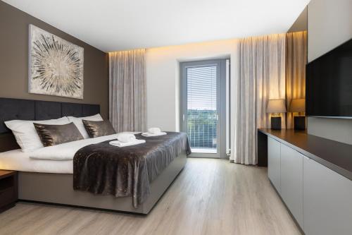 a bedroom with a bed and a large window at Hotel Awam in Hradec Králové