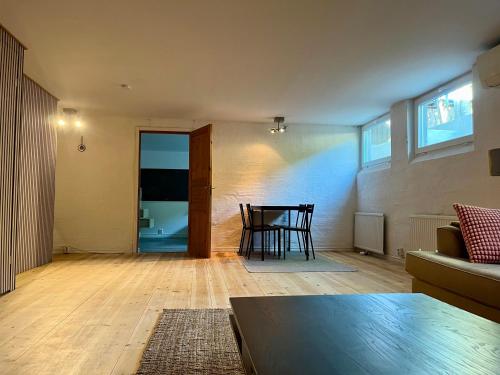 a living room with a table and a couch at Stenkällan - snabbuss 5 in Malmö