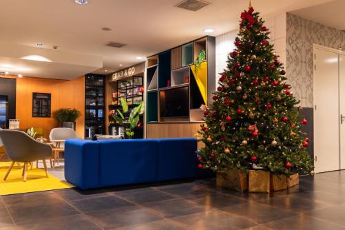 uma árvore de Natal no lobby de um hotel em Holiday Inn Eindhoven Centre by IHG em Eindhoven