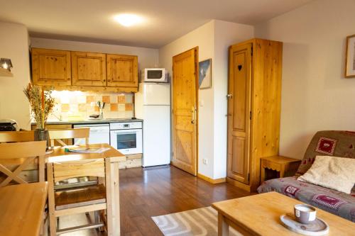 a small kitchen and living room with a table and a couch at Bel Appartement lumineux au coeur de la station de Vars in Vars