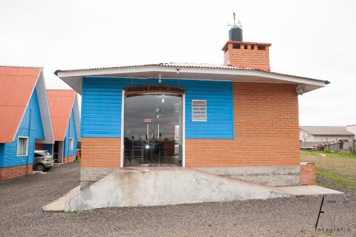 un edificio blu e arancione con una porta a vetri di Pousada Cristal Serra a Cambará