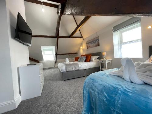 a bedroom with two beds and a flat screen tv at Tintagel Arms Bed and Breakfast in Tintagel