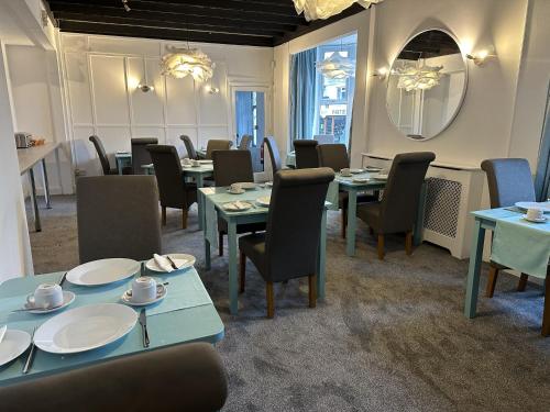 - une salle à manger avec des tables, des chaises et un miroir dans l'établissement Tintagel Arms Bed and Breakfast, à Tintagel