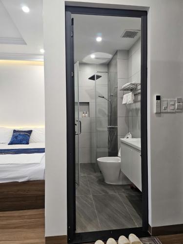 a bathroom with a shower and a toilet and a bed at Hoa Đảo Vua in Binh Hai