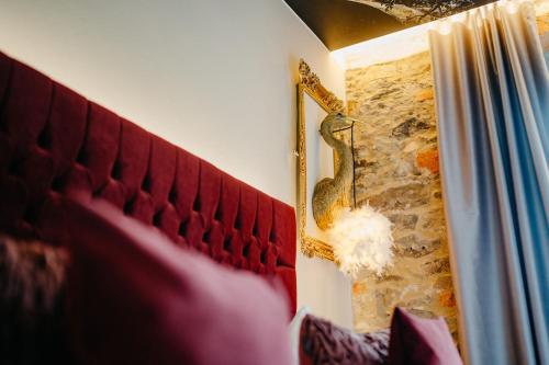 een slaapkamer met een rood hoofdeinde en een muur bij Historischer Gasthof Zum Anker Wachau in Wachau