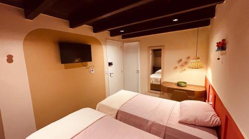 a small room with two beds and a television at Casa 678 in Belém