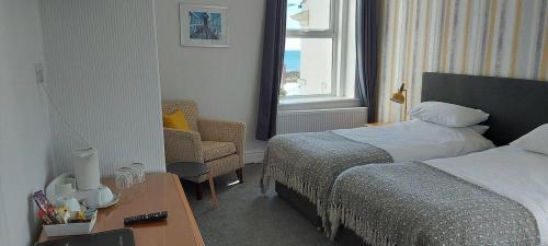 a hotel room with a bed and a chair at Kings' House in Douglas