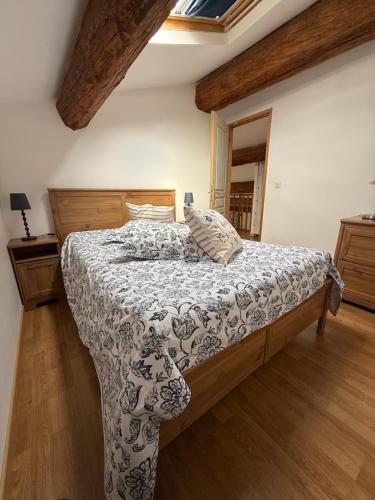 a bedroom with a bed with a comforter and a window at Gîte au cœur d un caveau de dégustation de vin in Olonzac