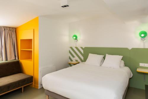 een slaapkamer met een groot bed en een stoel bij OLDEGAR Hôtel in Nantes