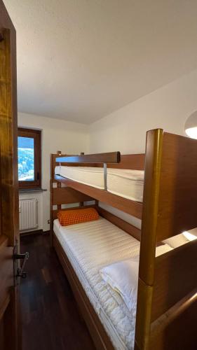 two bunk beds in a room with a window at L'Atelier du Temps - Voicing House in Courmayeur