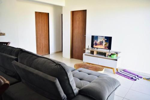 アハイアウ・ド・カボにあるIRIS Pousada - Frente à praiaのソファとテレビのあるリビングルーム