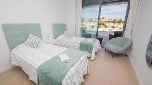 una camera d'albergo con due letti e una finestra di Villa Sapphire 62 a Castillo de Sabinillas