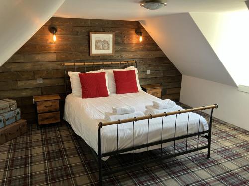 una camera da letto con un letto con cuscini rossi di Culrain Cottage a Fort Augustus