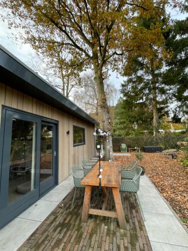 a patio with a wooden table and chairs at De Eikenloft in Heerenveen