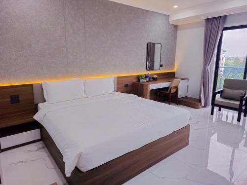 a bedroom with a bed and a desk and a tv at 阮黄酒店 in Hòa Ðình