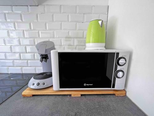 a microwave sitting on a stand with a blender on top of it at Cosy appartement, Nancy center in Nancy