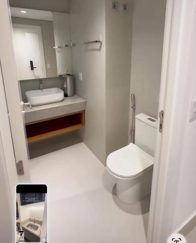 a white bathroom with a toilet and a sink at Porto 2 Life Resort in Porto De Galinhas