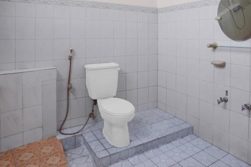 a bathroom with a toilet and a shower at Collection O near Universitas Negeri Padang formerly Hotel Amra in Padang