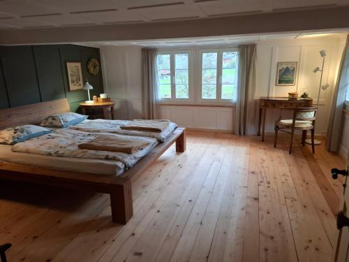 1 Schlafzimmer mit 2 Betten und Holzboden in der Unterkunft Mattishüüsli - Chalet with a little garden in Luchsingen