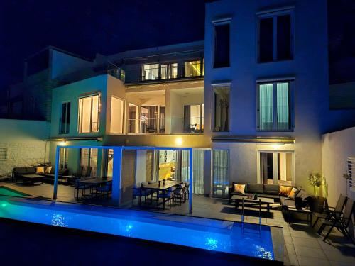 a house with a pool in front of it at night at Apartment Oliven Penthouse in Sutivan