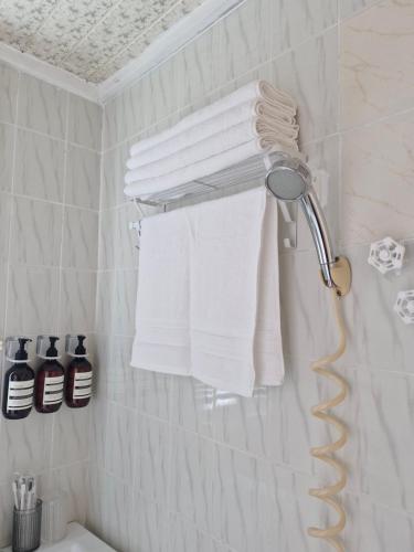 a towel rack with white towels on a wall in a bathroom at 스테이 노랑 stay norang in Daegu