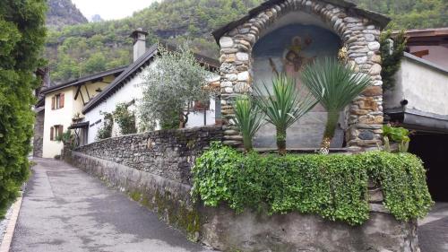 a building with a stone wall with plants on it at Casa San Cristoforo Studio in Maggia