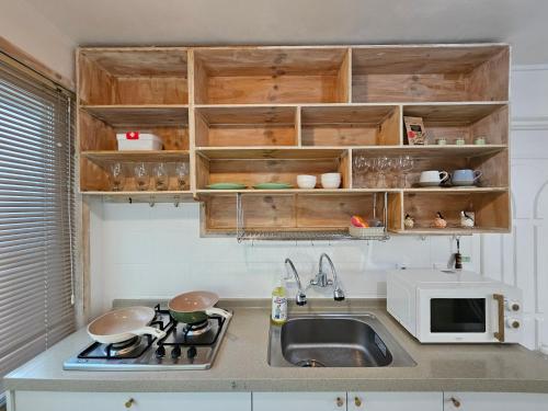 a small kitchen with a sink and a microwave at 스테이 노랑 stay norang in Daegu
