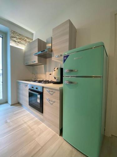 a kitchen with a green refrigerator and wooden floors at B&B Iris in Terlizzi