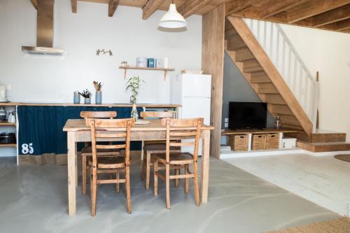 a kitchen with a wooden table and chairs at Loft avec filet d'habitation suspendu géant proche mer in Bouin