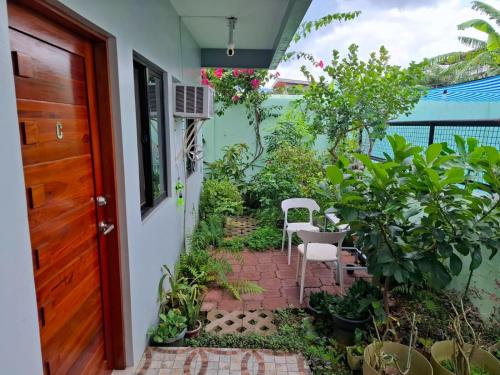 a patio with plants and a red door at Bleu Saphire Apartments in Los Baños