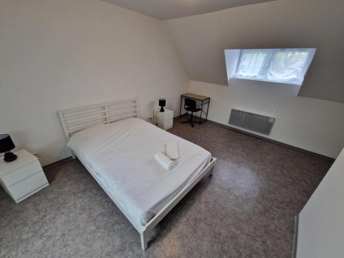 a bedroom with a white bed and a window at Spacieux 3 chambres Tout équipé in Feignies