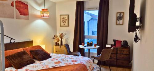 a bedroom with a bed and a table with chairs at L'Ambre - Moderne - Equipé - Douche in Lourdes