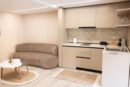 a kitchen with a couch and a table in a room at 3 Min To Center Stylish Stay's in Tirana
