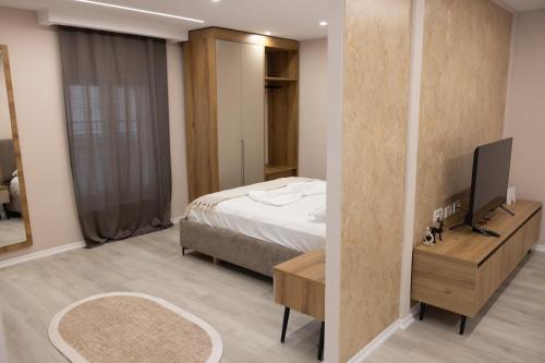 a bedroom with a bed and a television in it at 3 Min To Center Stylish Stay's in Tirana