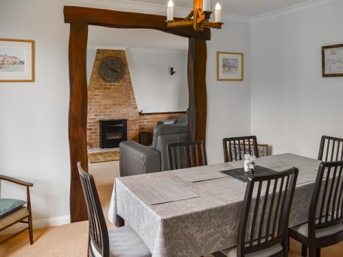 a dining room with a table and a fireplace at Rivendell in Burgh by Sands