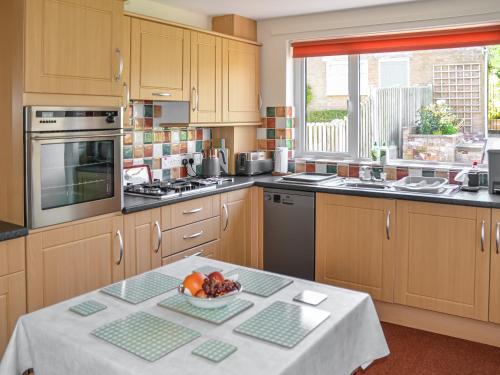 a kitchen with a table with a bowl of fruit on it at Rivendell in Burgh by Sands