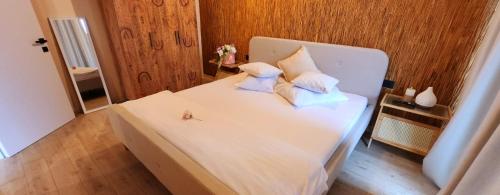 ein weißes Bett mit Kissen auf dem Zimmer in der Unterkunft Infinity ApartHotel Boutique - Gym Roof Top & Spa in Mamaia Nord – Năvodari
