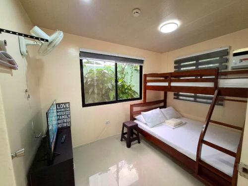 a bedroom with a bunk bed and a window at Bleu Saphire Apartments in Los Baños