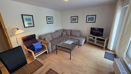 un salon avec un canapé et une télévision dans l'établissement Haus am See Zislow Whg 2, à Zislow