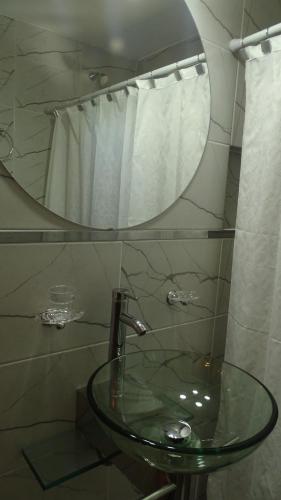 a bathroom with a glass sink and a mirror at Don Andrés y doña cuca in Merlo