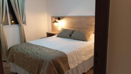 a bedroom with a bed with a wooden headboard at Don Andrés y doña cuca in Merlo