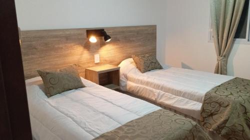 a hotel room with two beds and a lamp at Don Andrés y doña cuca in Merlo