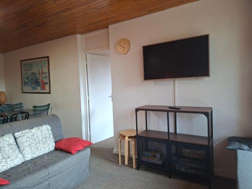 a living room with a couch and a flat screen tv at Chamrousse 1750 - Le Taillefer - Appartement classé 3 étoiles in Chamrousse