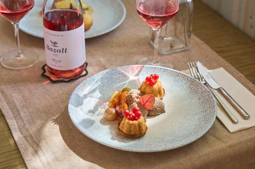 a plate of food on a table with a bottle of wine at Icce Borbirtok - Wine, Dine & Rest in Monoszló