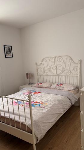 een wit bed met een wit hoofdeinde in een slaapkamer bij Zentrale und gemütliche Wohnung in Neuss in Neuss