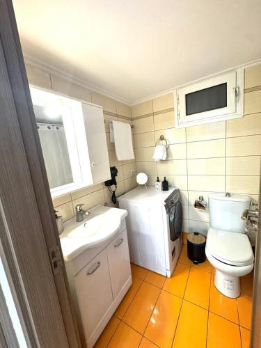 a small bathroom with a toilet and a sink at Blue Port Beach House in Rafina
