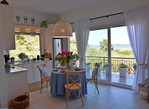 a kitchen and dining room with a table and a balcony at Philippos 1 in Diaporos