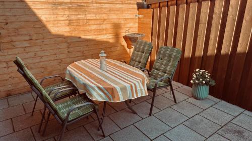 une table et quatre chaises sur la terrasse dans l'établissement Ferienhaus Dittert, à Müritz