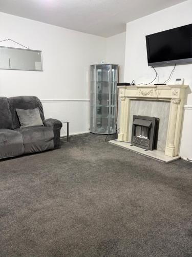 a living room with a couch and a fireplace at Belexsia Guest House in Stoke on Trent