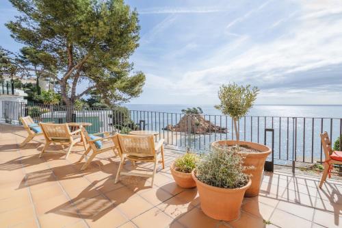 普拉加德阿罗Park Hotel San Jorge & Spa by Escampa Hotels的一个带椅子的海景庭院